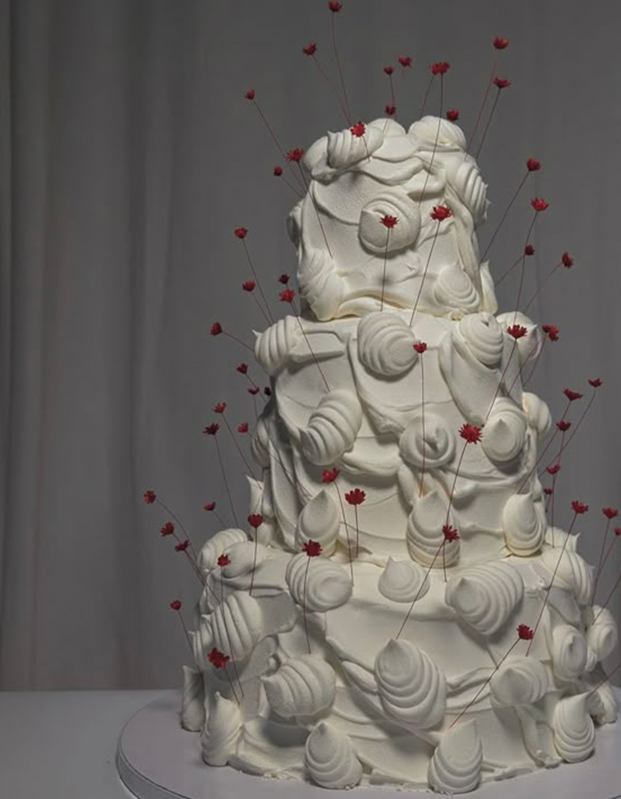 7 Wedding Cake Trends for 2025: Inspiring Designs for Modern Couples 7 White three-tier wedding cake with red fresh floral details.