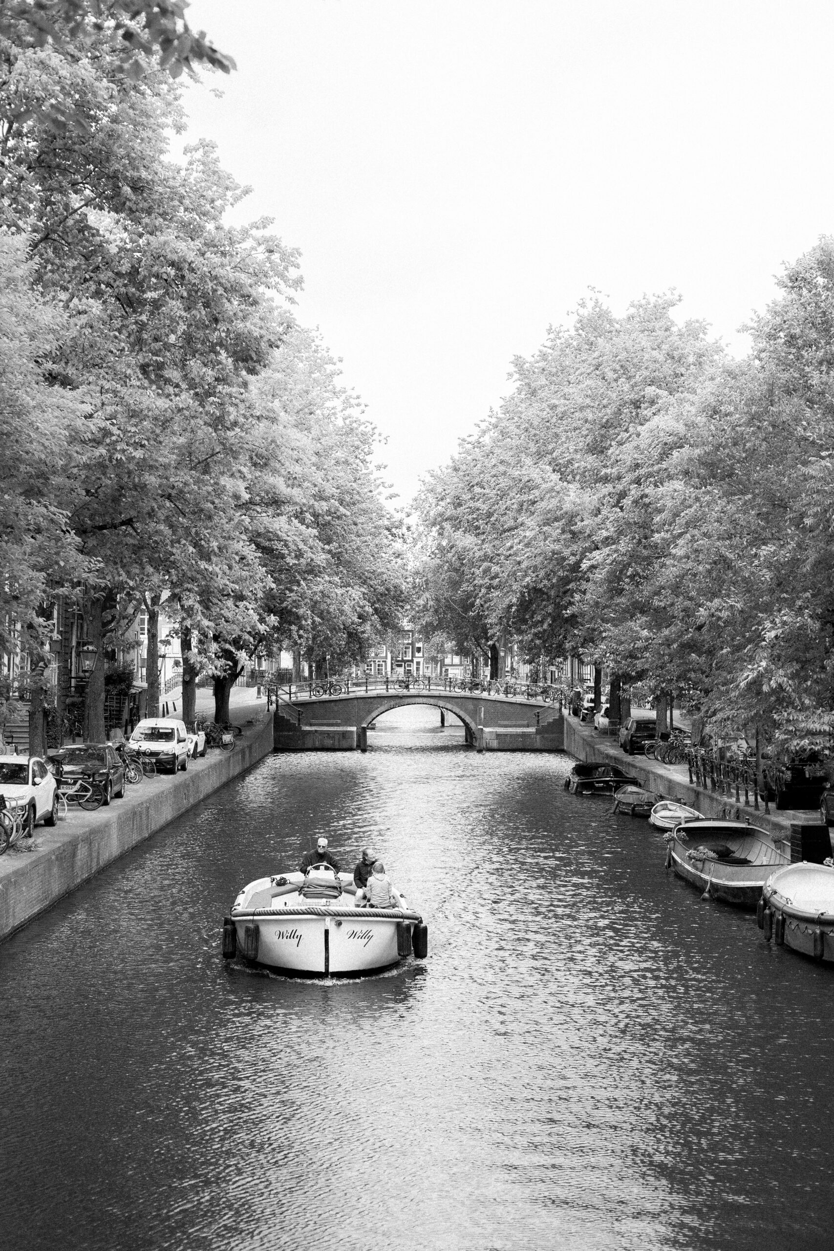 Planning a Surprise Proposal? Hire an Engagement Photographer in Amsterdam 8 Amsterdam canal with boats and a bridge in the background