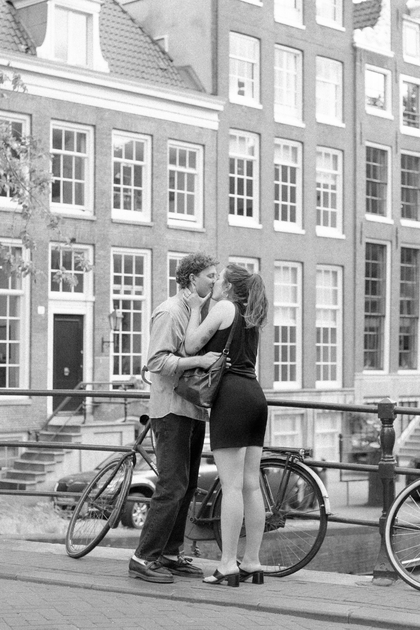 Planning a Surprise Proposal? Hire an Engagement Photographer in Amsterdam 7 Couple kissing near a canal in Amsterdam after getting engaged