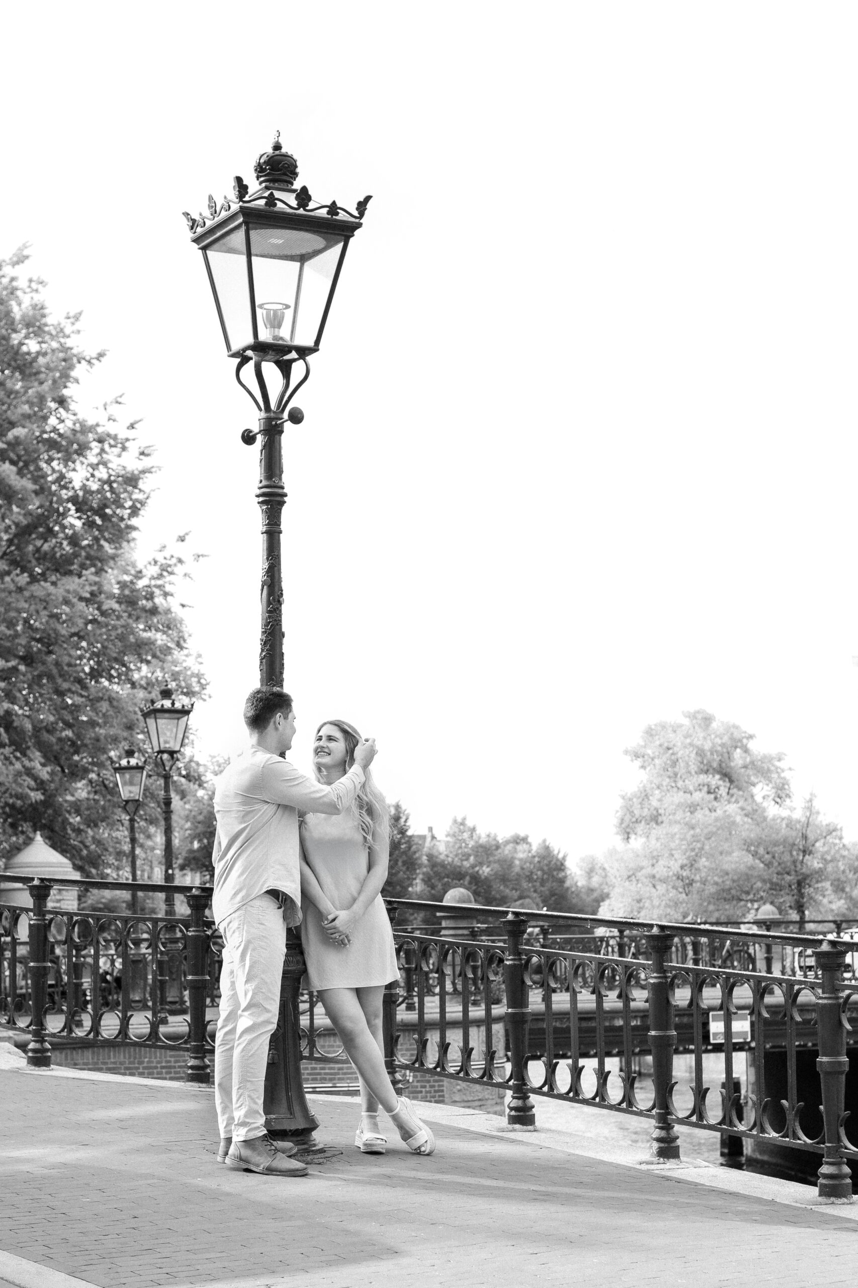 Couple Photoshoot in Amsterdam: A Romantic Escape Captured in Editorial Style 8 Couple standing under a city light in Amsterdam, guy is gently moving hair from the woman's face