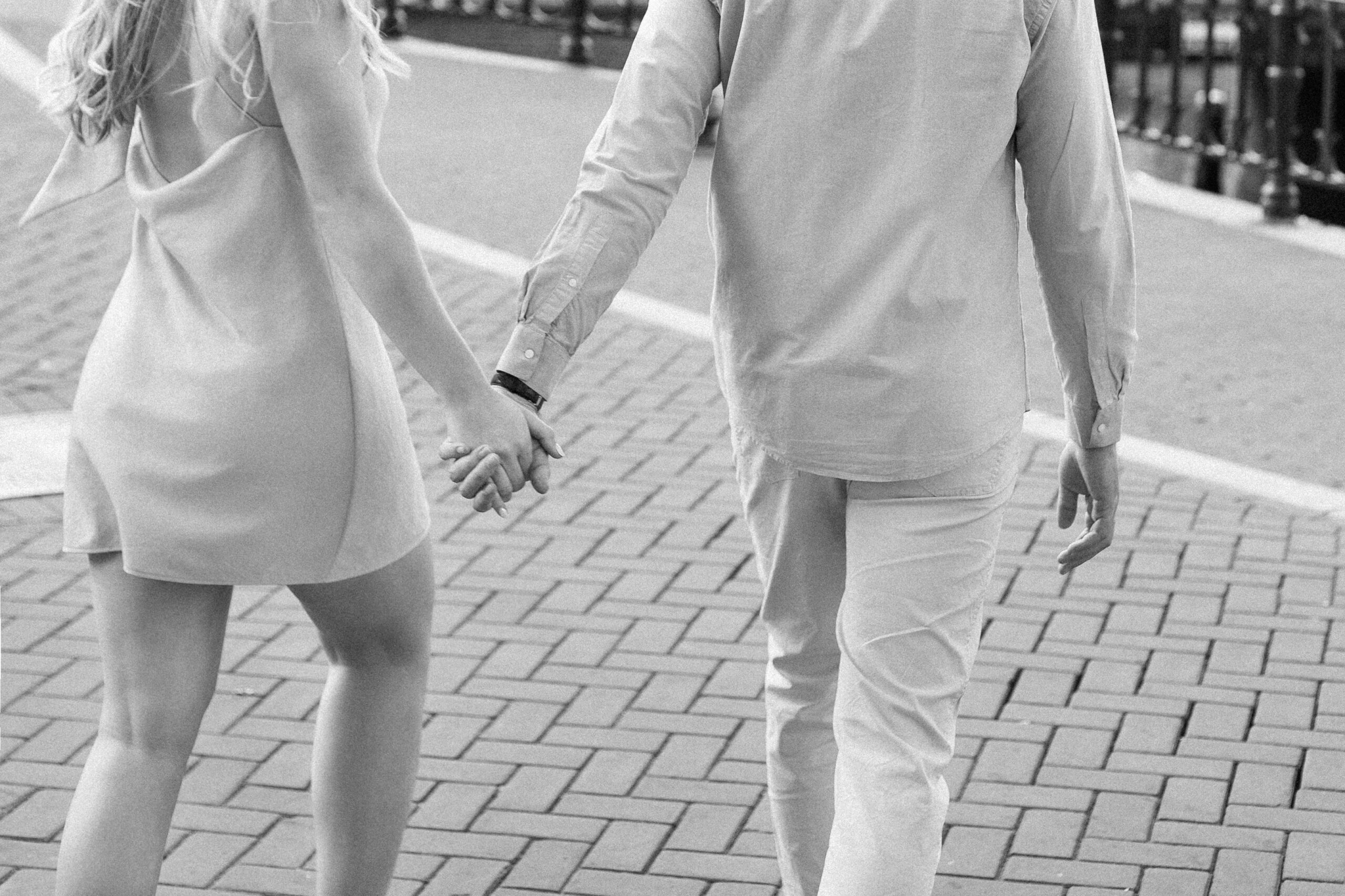 Close up photo of a couple walking in Amsterdam holding hands