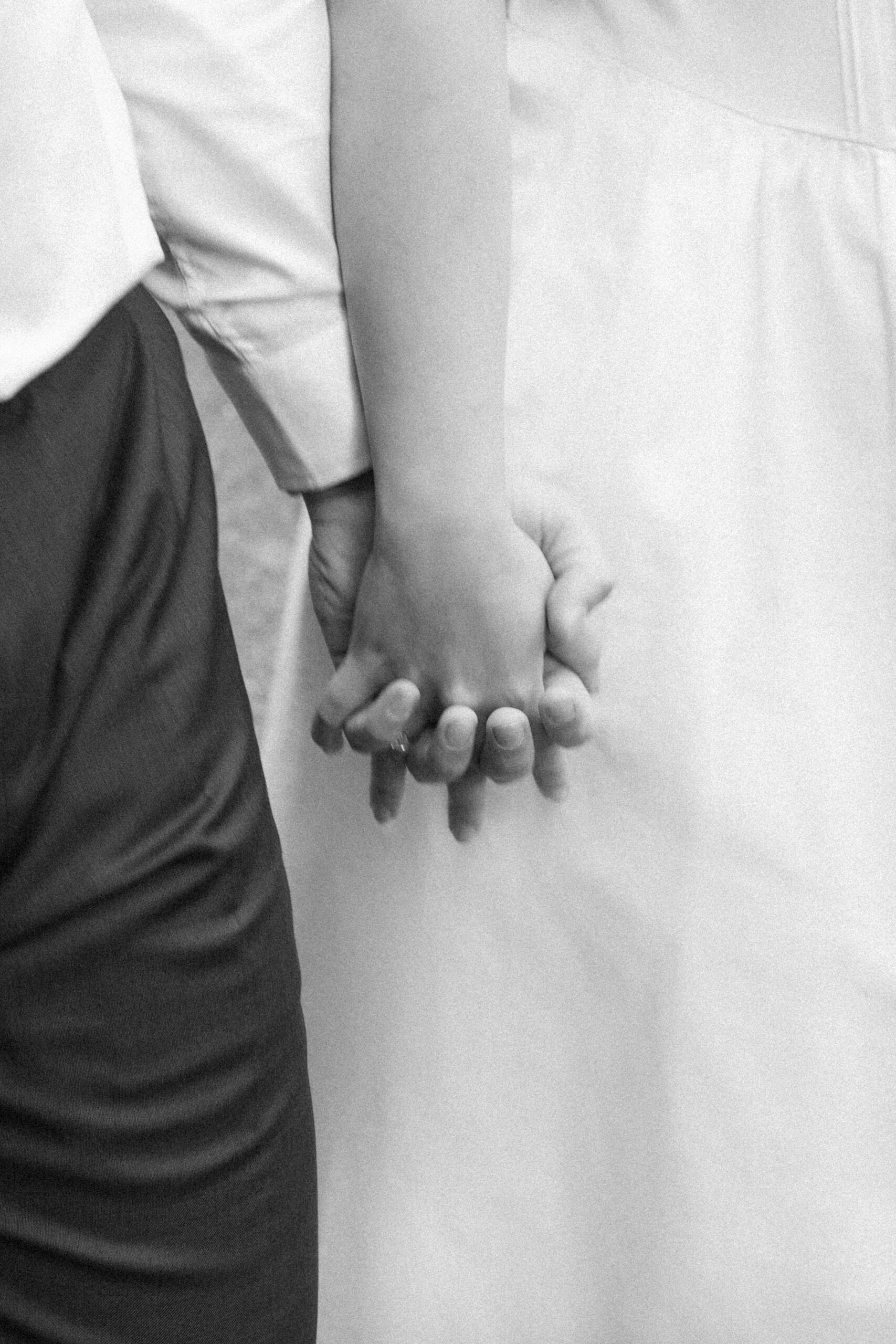 Black and white close up photo of a couple holding hands