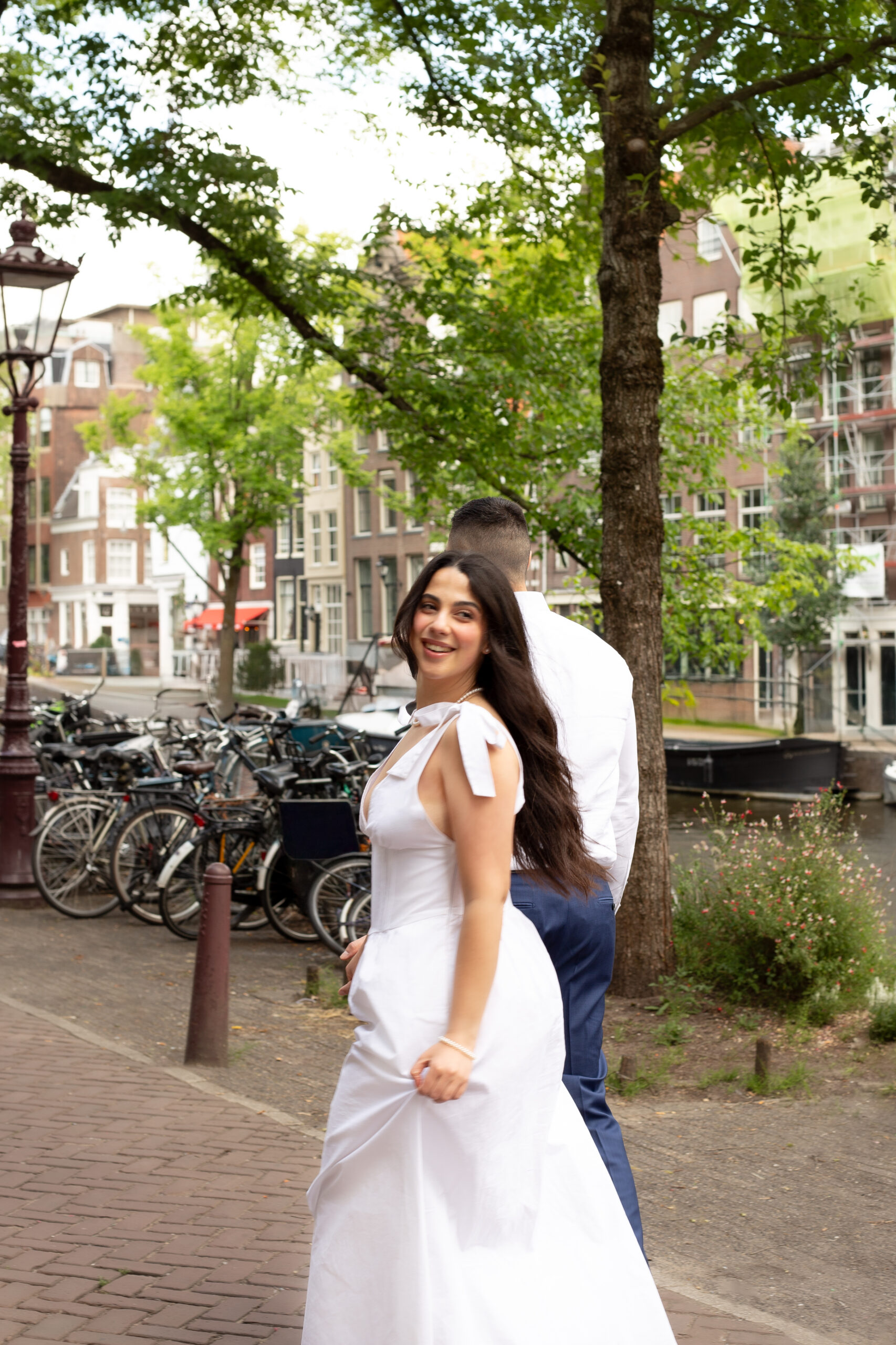 Editorial style photo of a bride and groom walking on a street in Amsterdam after their elopement