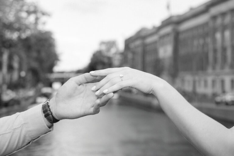 Black and white close up photo of an engaged couple holding hands - beautiful diamond ring on the girls hand
