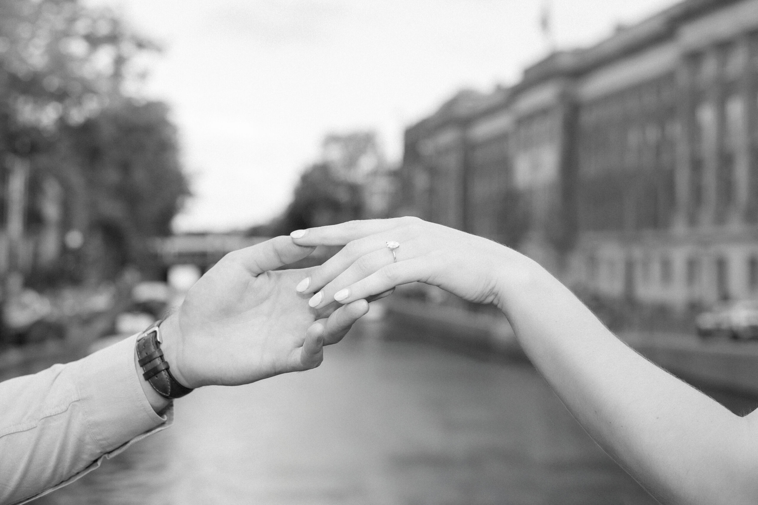 Black and white close up photo of an engaged couple holding hands - beautiful diamond ring on the girls hand