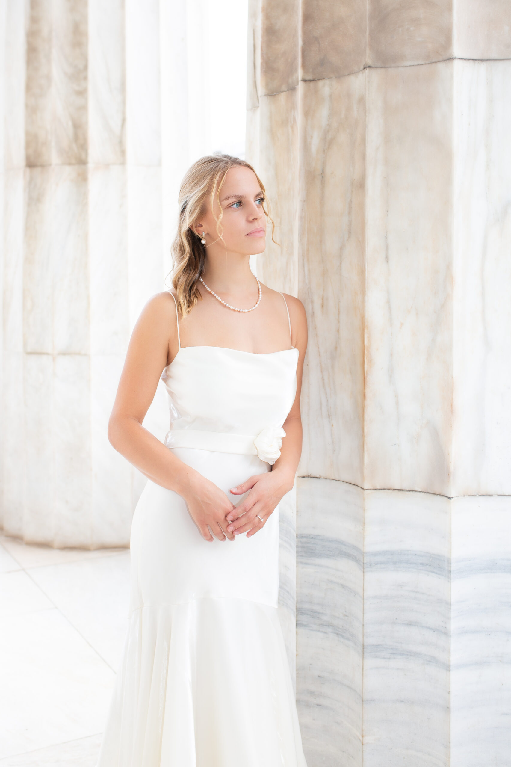 Beautiful, editorial style portrait of the bride leaning on the column of a monumental building in Athens, Greece