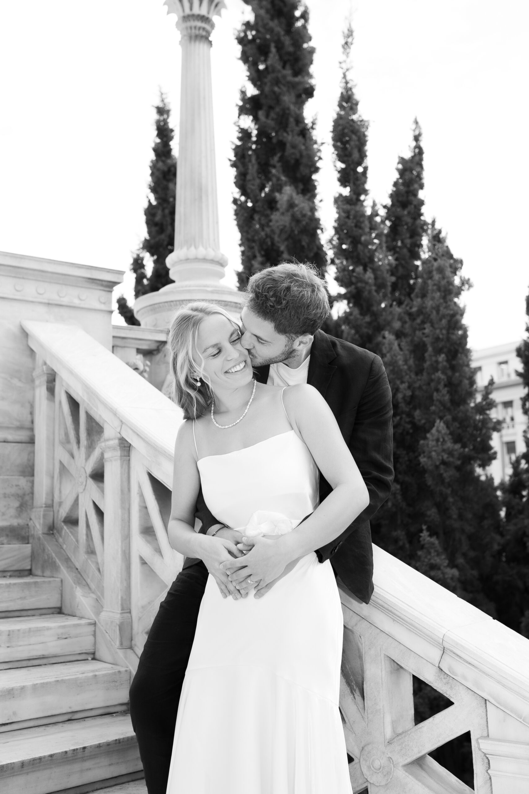 Candid shot of bride and groom hugging and laughing, captured by a destination wedding photographer in Athens, Greece