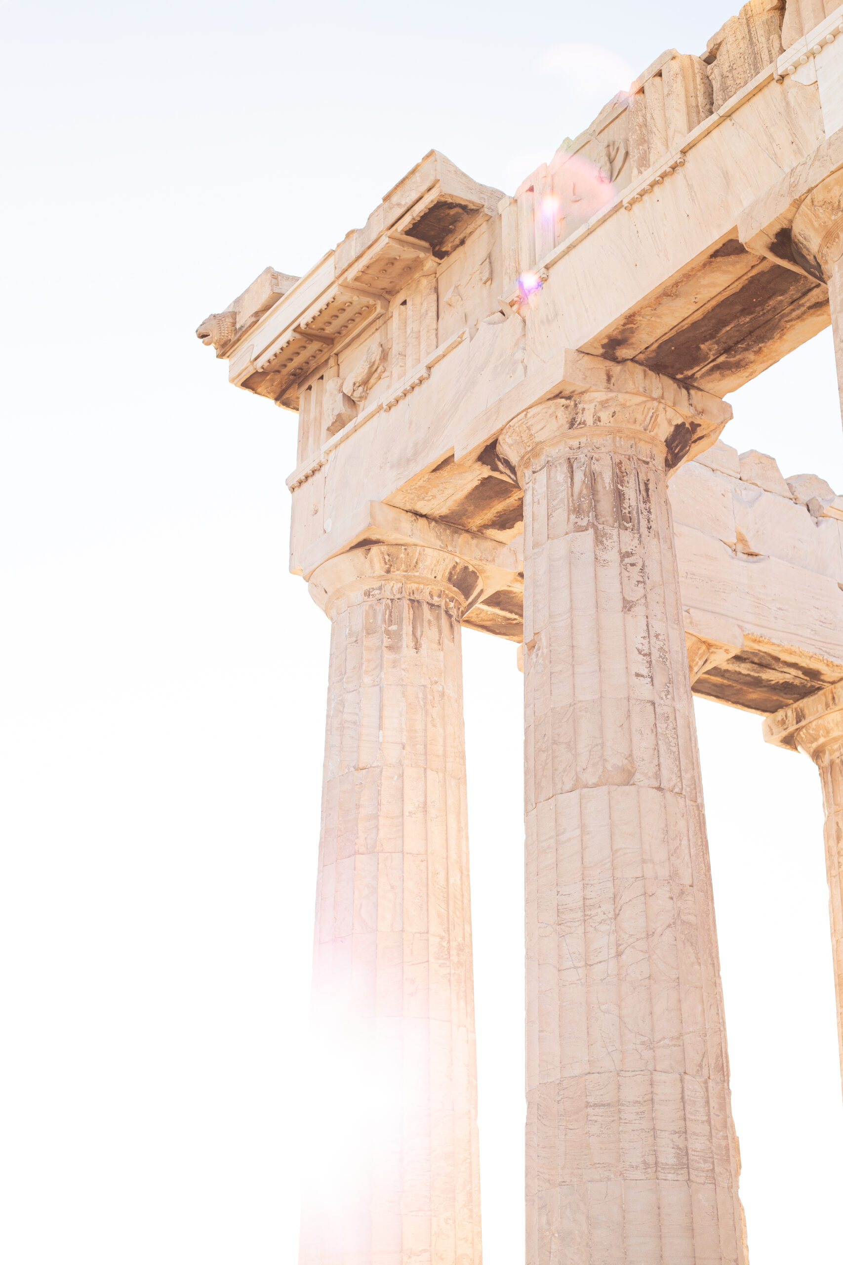 The Acropolis of Athens - columns of the Parthenon temple with sun rising in the background