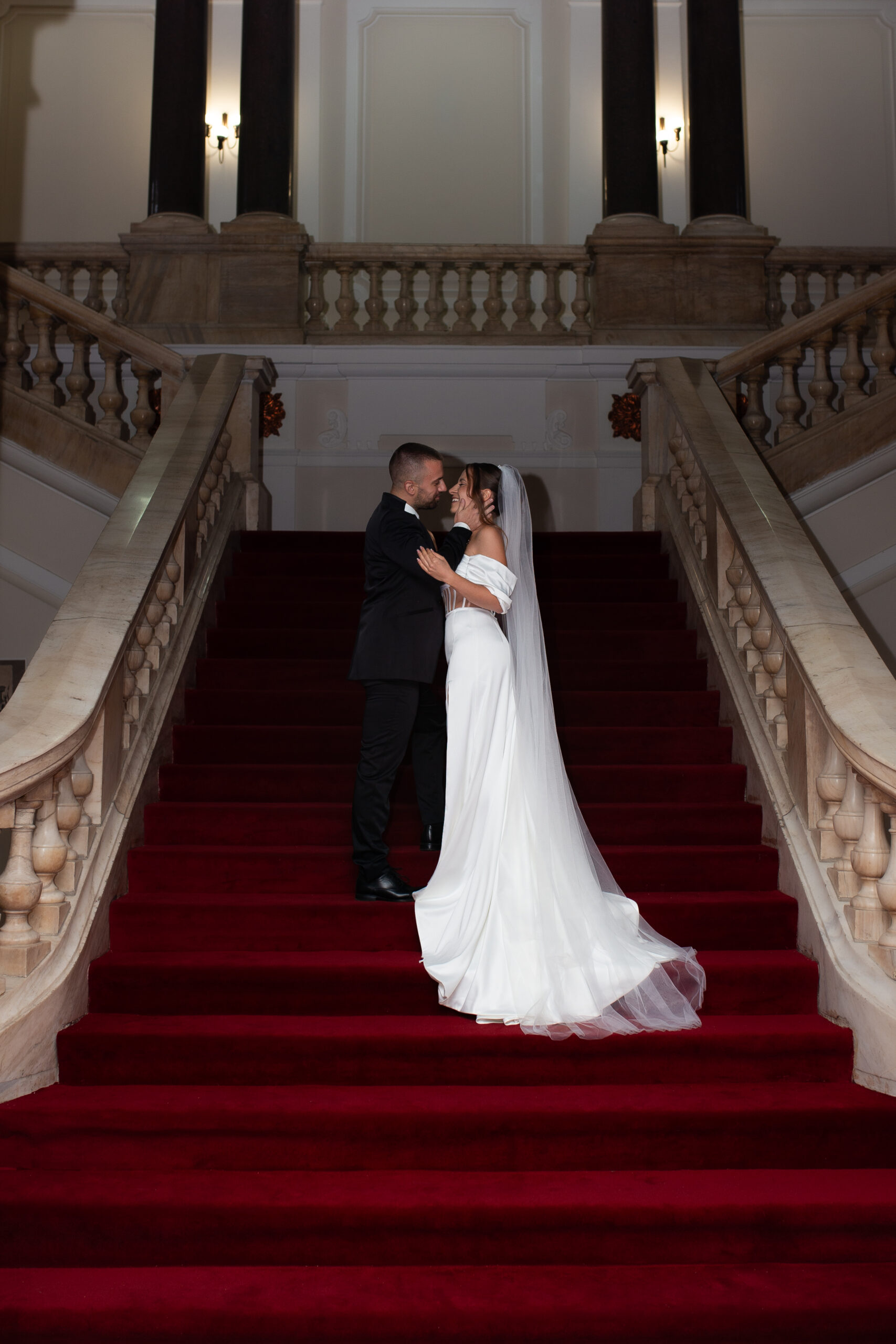 Bride and groom on the grand staircase of a European villa