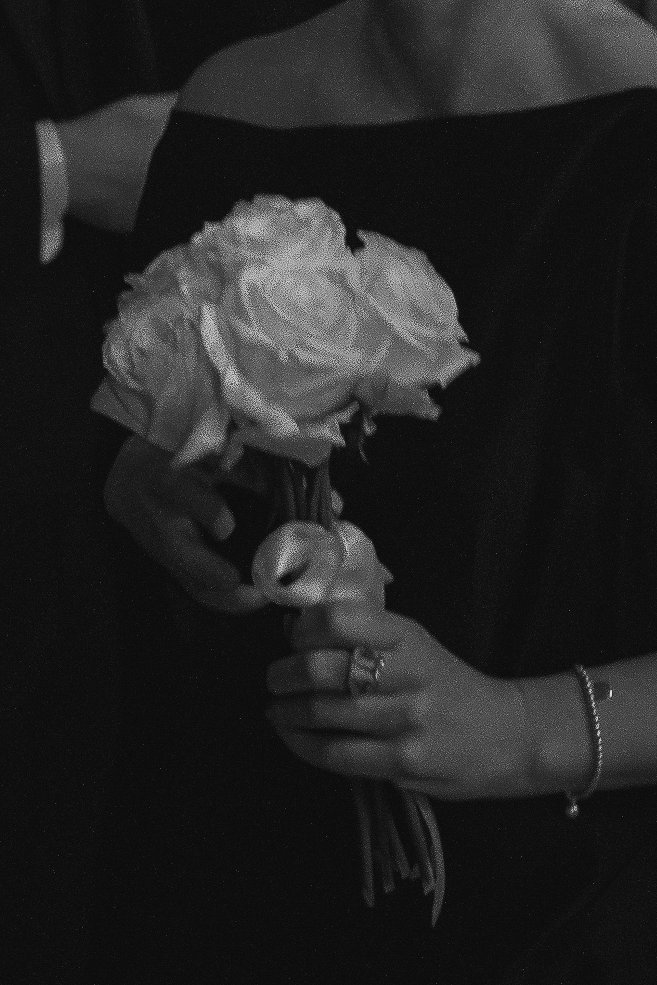 Detalj buketa belih ruža u rukama mlade tokom crkvenog venčanja u Vaznesenjskoj crkvi u Beogradu, umetnička crno-bela fotografija