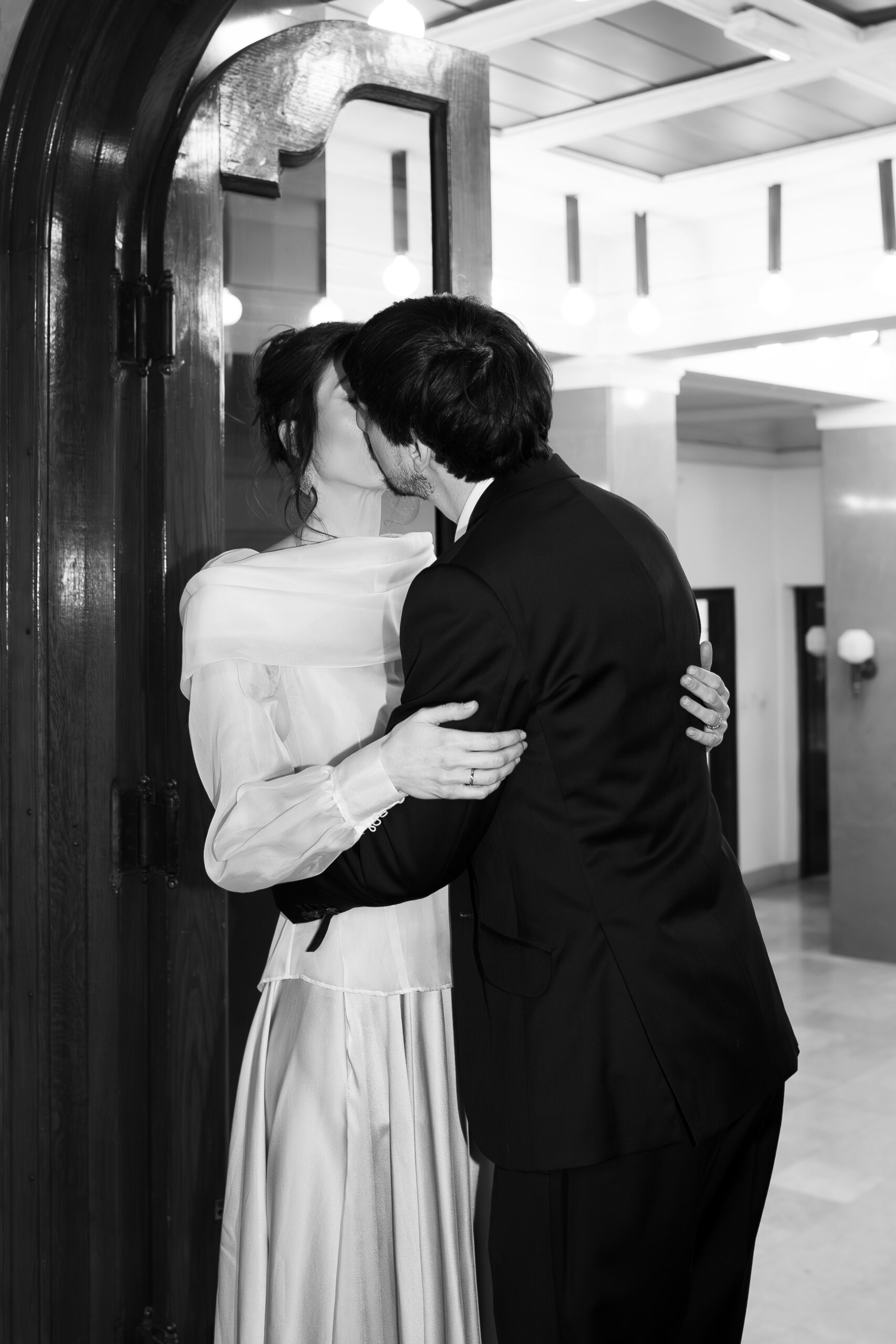 Mladenci se ljube u enterijeru Kolarčeve zadužbine tokom post-wedding fotografisanja u Beogradu, elegantna editorial wedding fotografija u crno-beloj tehnici.