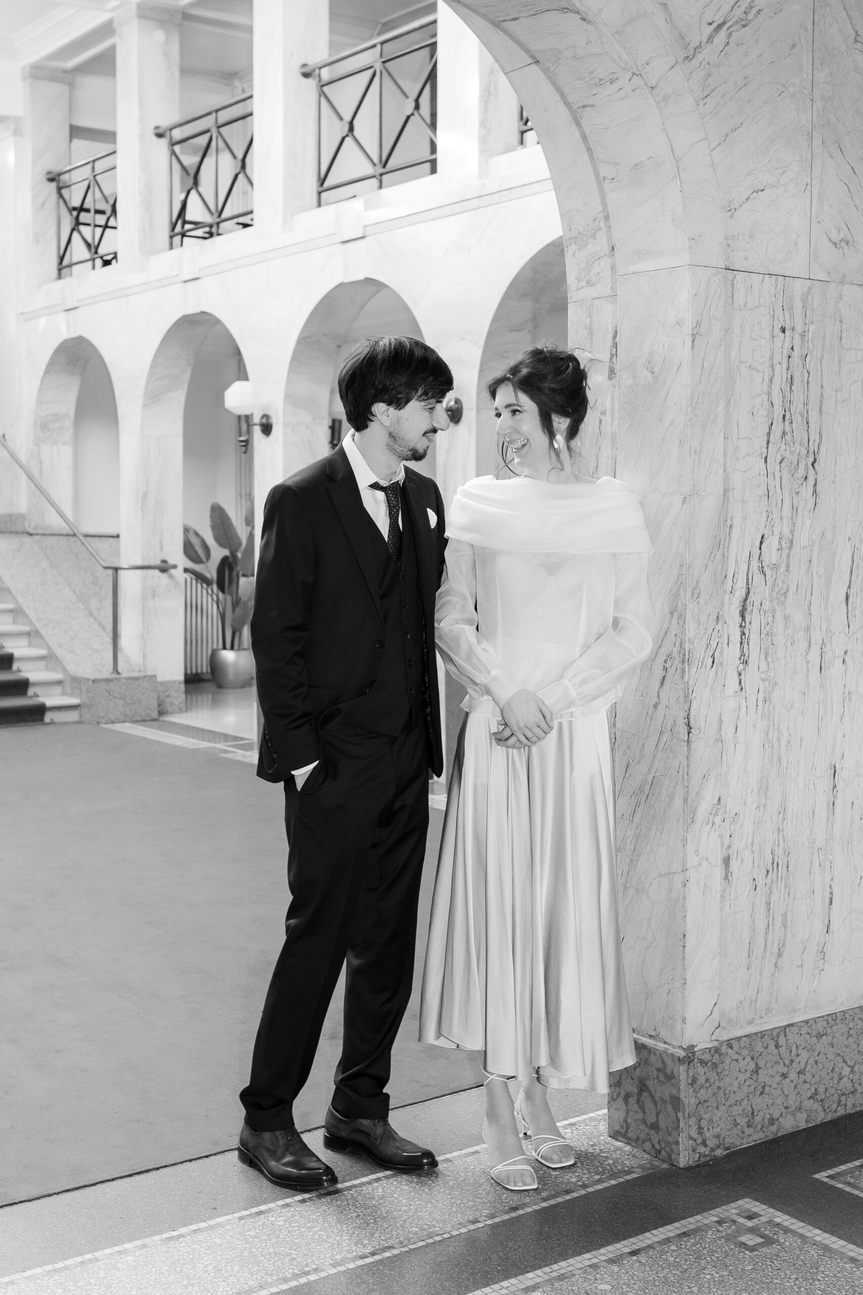 Mladenci stoje jedno pored drugog u Kolarčevoj zadužbini, spontani osmeh i editorial post-wedding fotografija sa arhitektonskim detaljima Beograda.