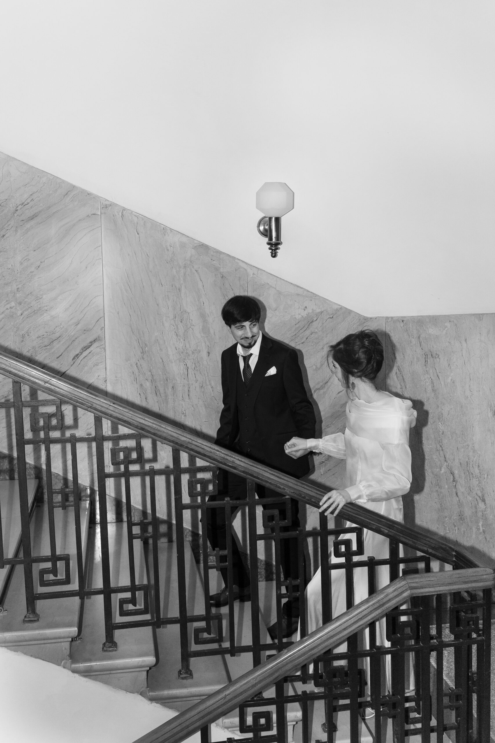 Mlada i mladoženja hodaju uz stepenice u Kolarčevoj zadužbini, editorial wedding fotografija sa naglaskom na prostor i pokret.