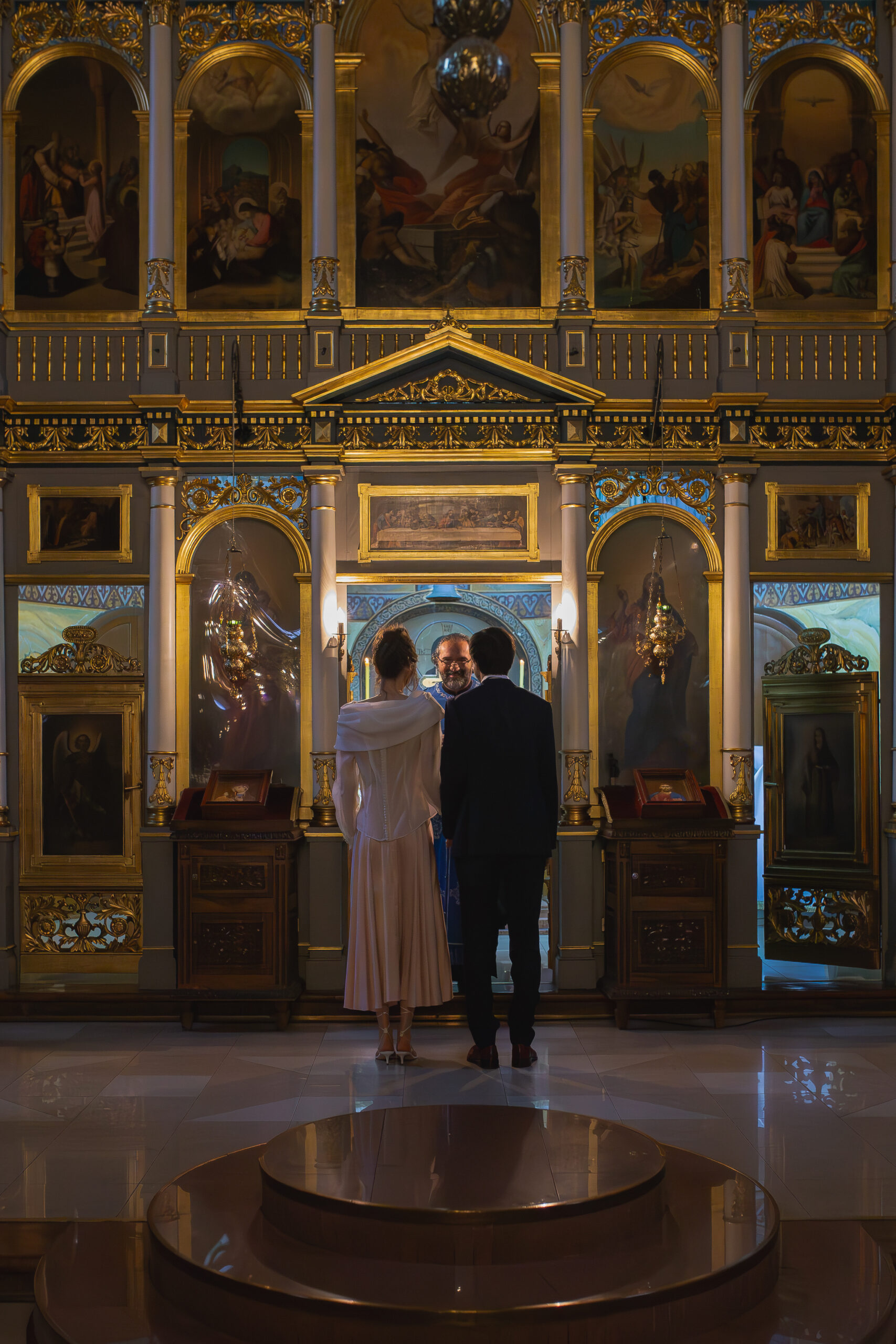 Mlada i mladoženja stoje pred ikonostasom tokom crkvenog venčanja u Vaznesenjskoj crkvi u Beogradu, klasična pravoslavna ceremonija