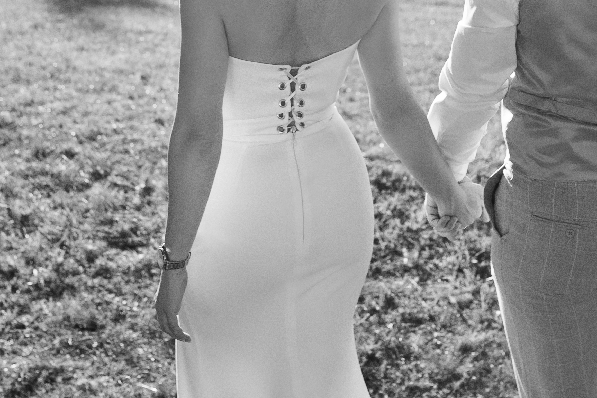 Detalj leđa mlade u venčanici, mladenci drže ruke tokom šetnje na Kosmaju