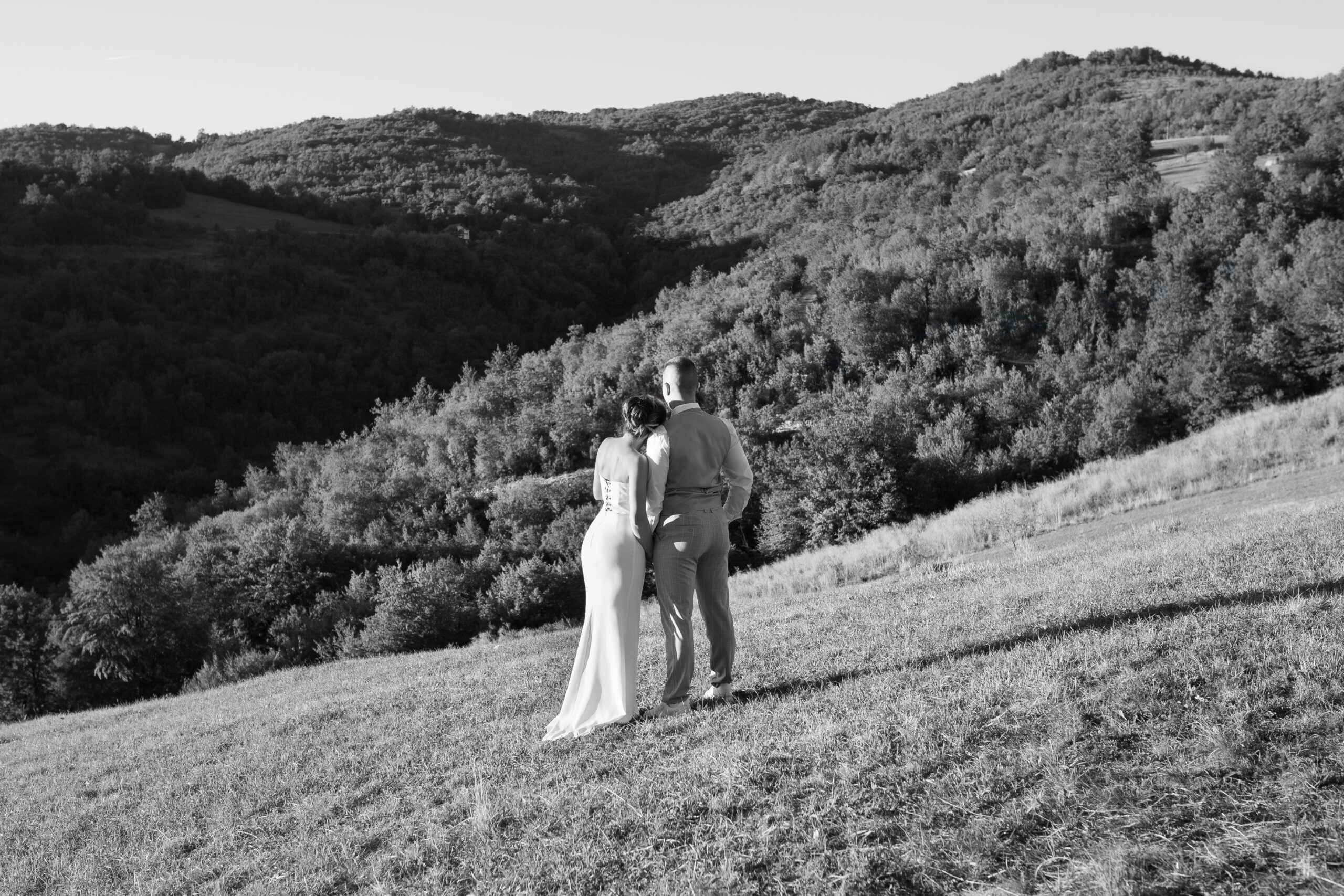 Mladenci leđima okrenuti pejzažu Kosmaja, romantična wedding fotografija u prirodi