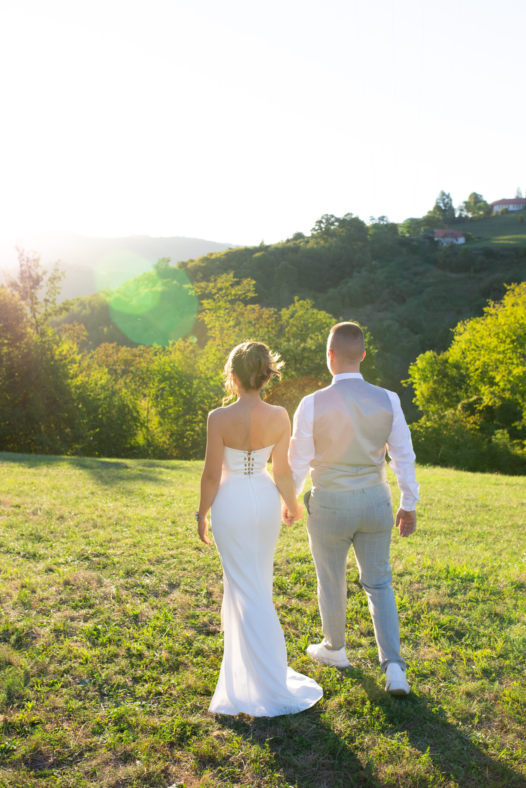 Mladenci hodaju držeći se za ruke na Kosmaju u zlatnom satu, venčanje u prirodi