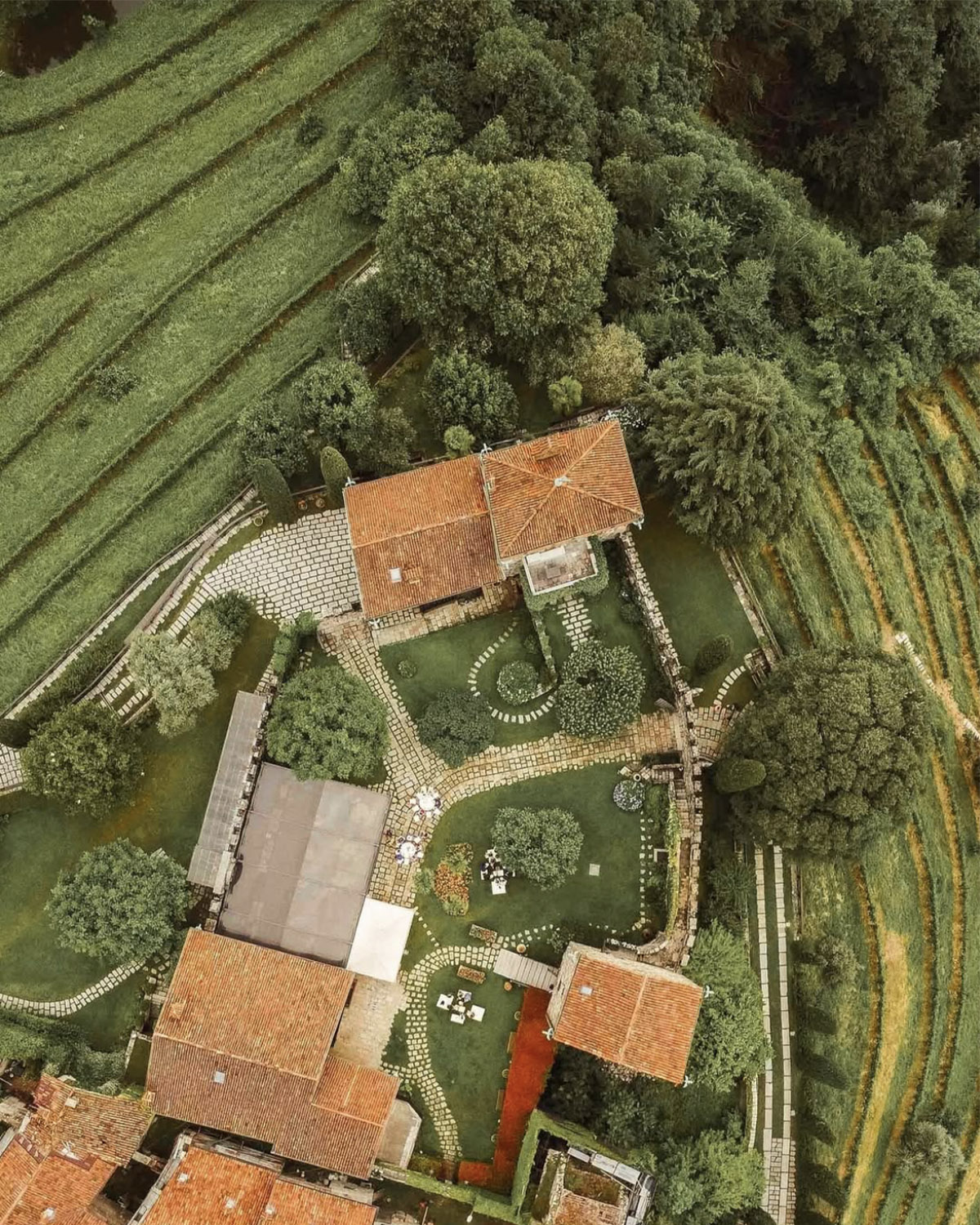 Bergamo countryside – top-down aerial of a rustic Italian estate with terracotta roofs and manicured gardens, styled in a refined editorial wedding aesthetic.