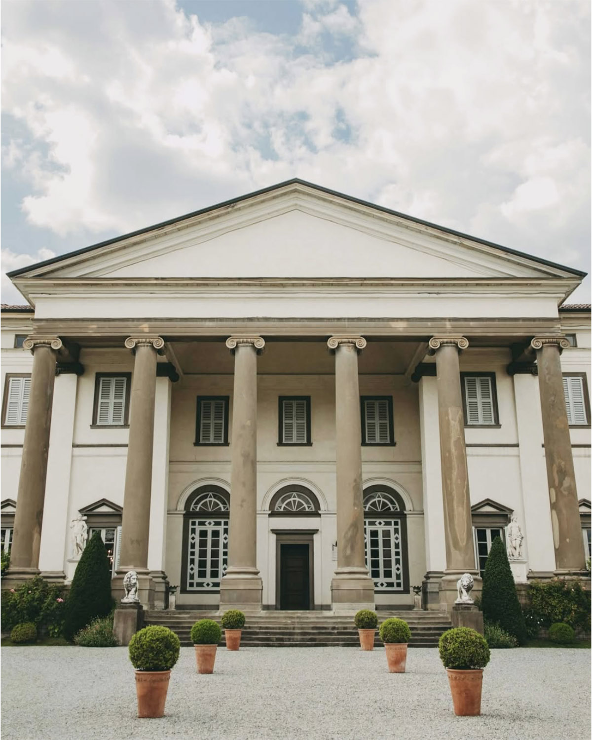 Bergamo, Italy neoclassical villa façade with tall columns and symmetrical architecture, captured in a clean, timeless editorial architectural style.