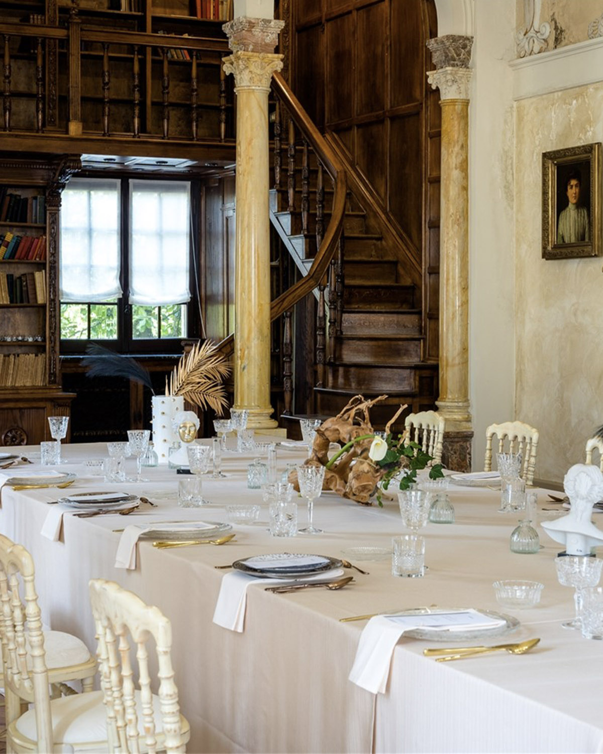 Bergamo, Italy intimate reception setup inside a rustic library-like room with wooden staircase and elegantly set table, styled in a warm editorial wedding detail shot.
