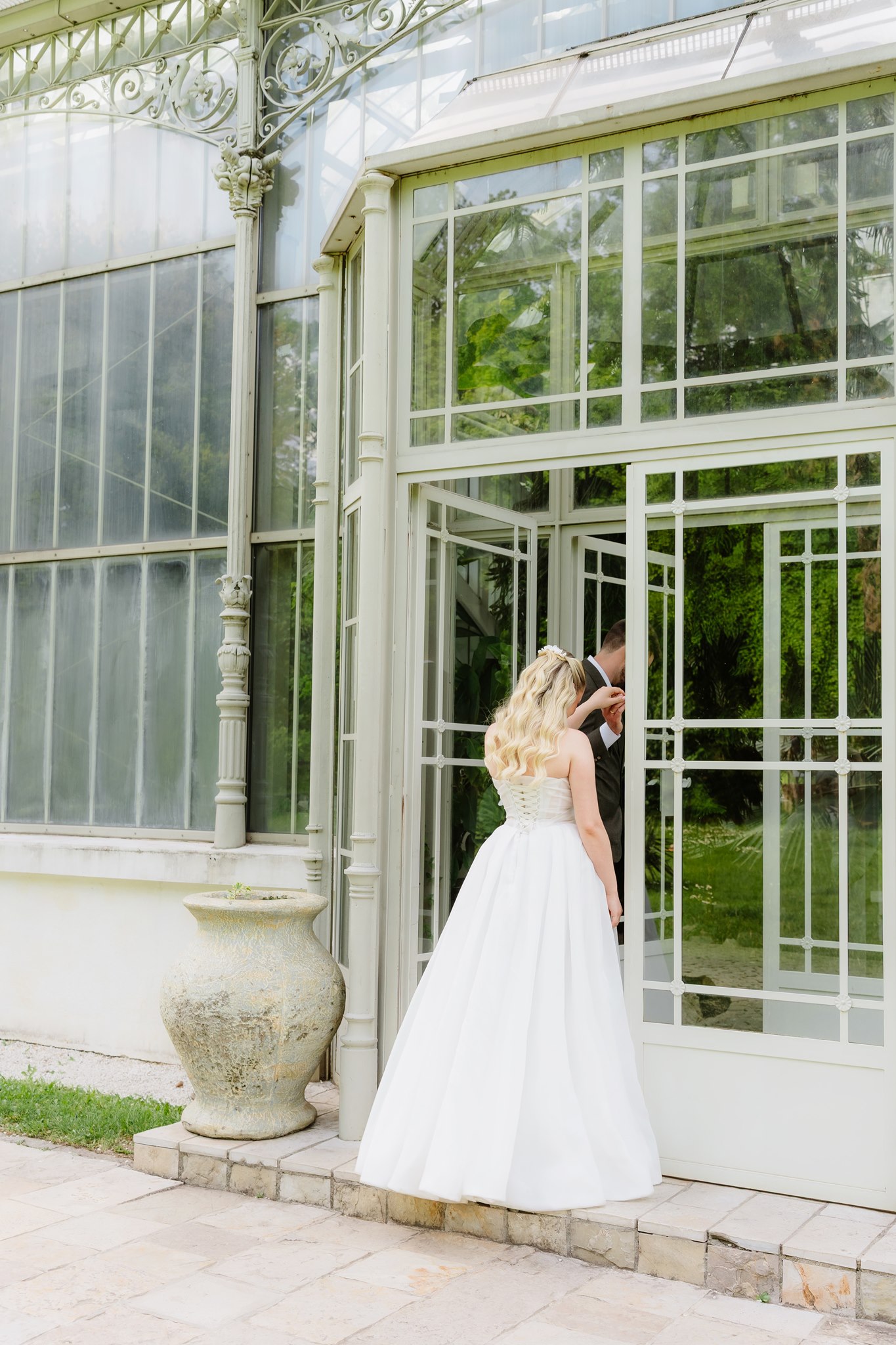 Belgrade Botanical Garden greenhouse entrance, a bride and groom share a quiet moment beside the open conservatory doors, photographed in a soft and romantic editorial style.