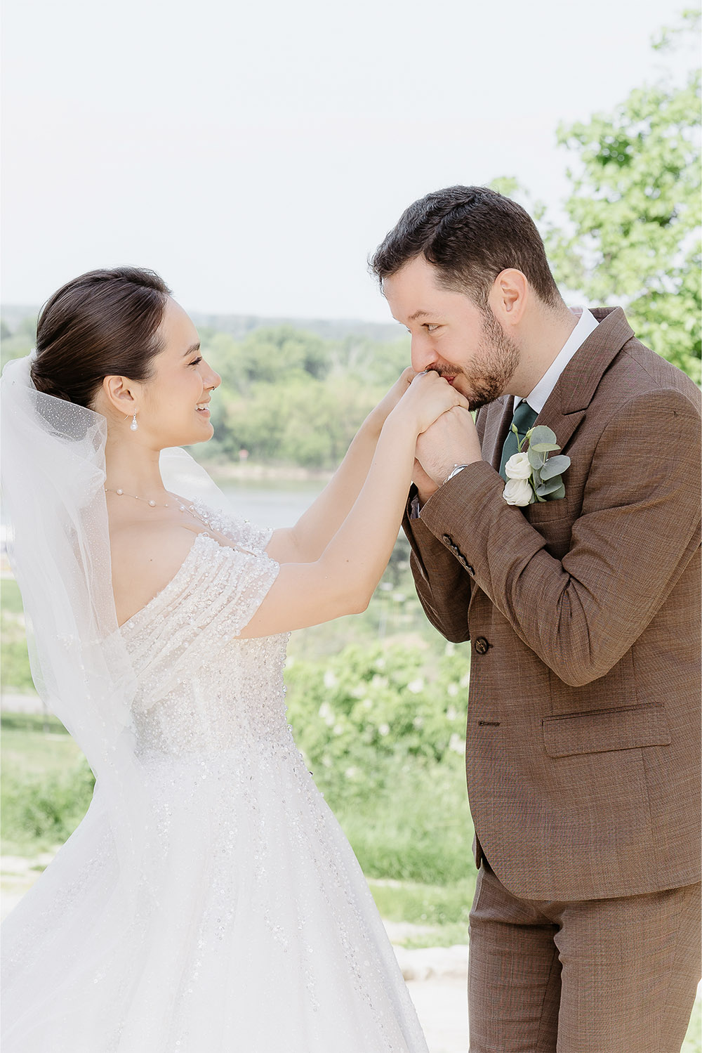 At Kalemegdan Fortress in Belgrade, a bride and groom share a quiet moment beneath a stone arch overlooking the river in a light-filled editorial wedding portrait.