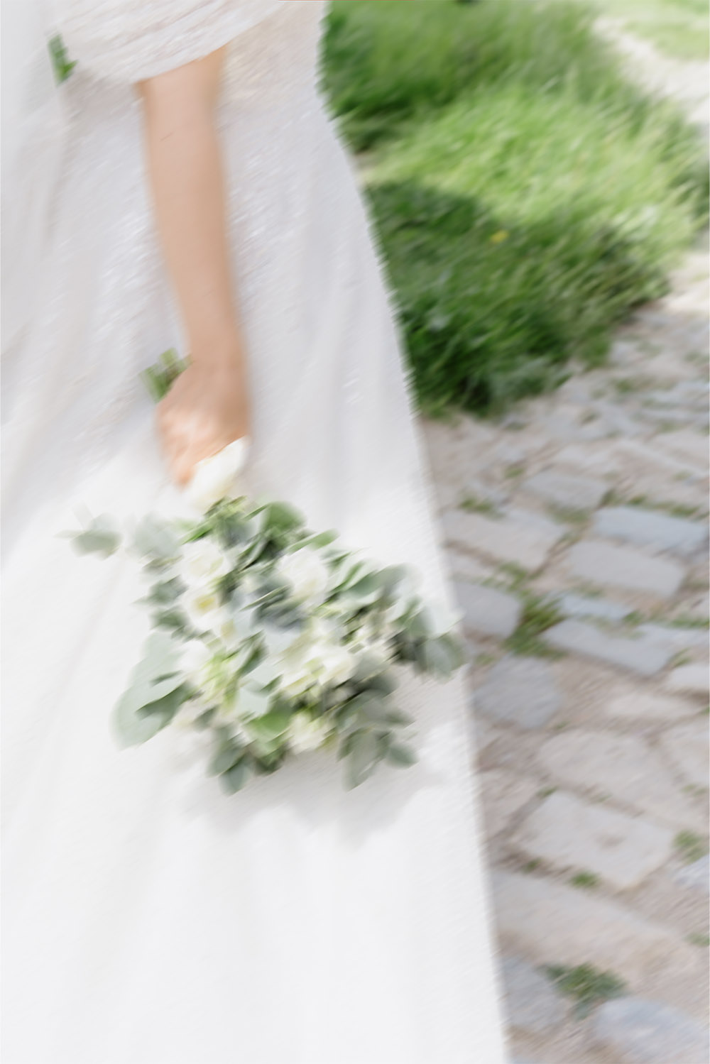 At Kalemegdan Fortress in Belgrade, the bride carries a bouquet through the historic grounds in a motion-blurred editorial detail photograph.
