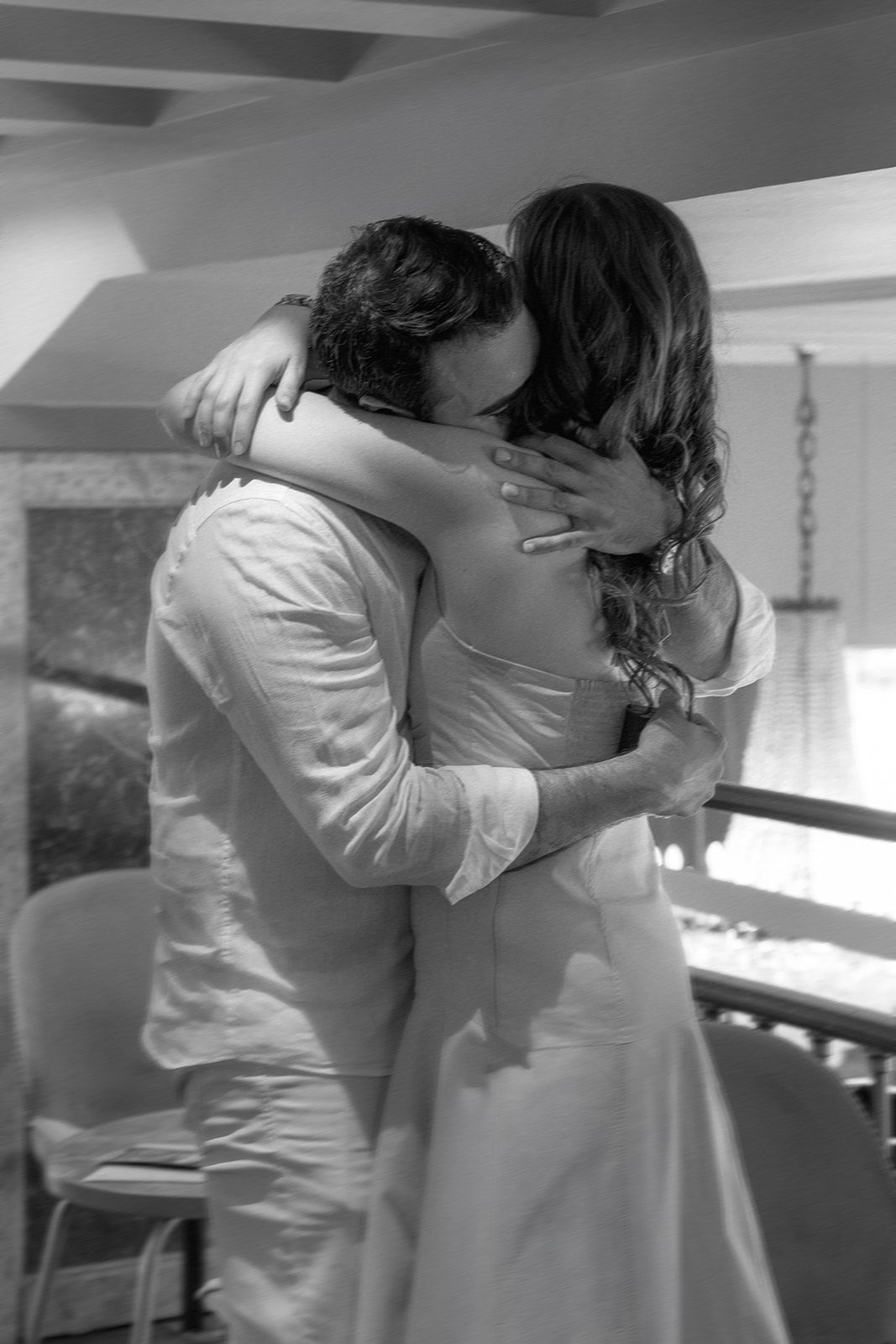 Editorial black and white proposal photo inside Akademija Bookstore in Belgrade capturing an emotional embrace moments after the engagement.