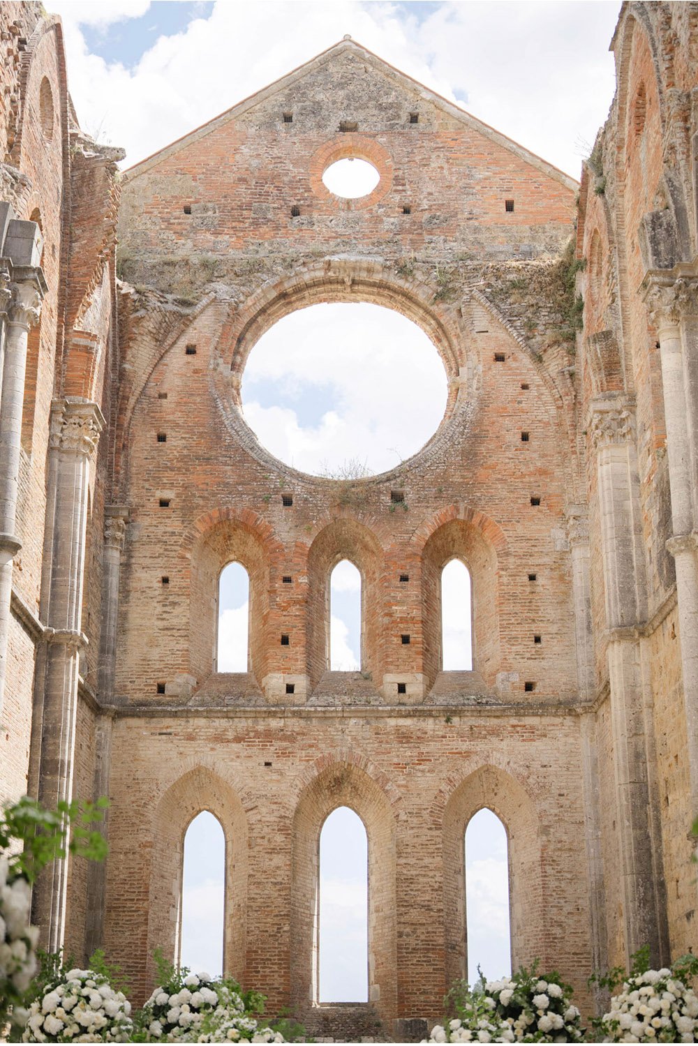 San Galgano Abbey: The dramatic interior of San Galgano Abbey in Tuscany, Italy, showcasing its weathered brick walls, soaring arches, and open sky in an elegant editorial style.